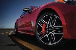 Close view of the bottom tire area of a red 2022 Kia Stinger. | Kia service in Sherwood, AR.