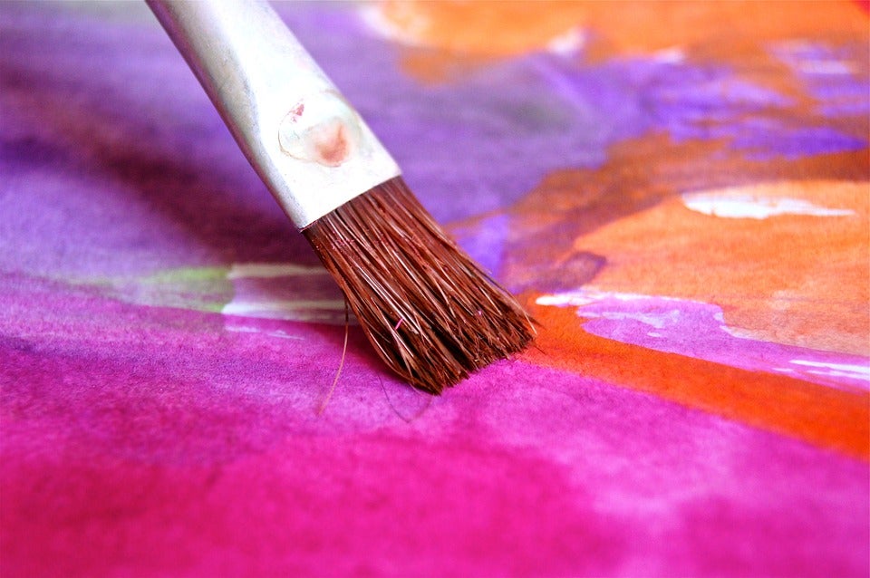 A small paint brush stroking paint on a colorful painting. | Local art in Central Arkansas.