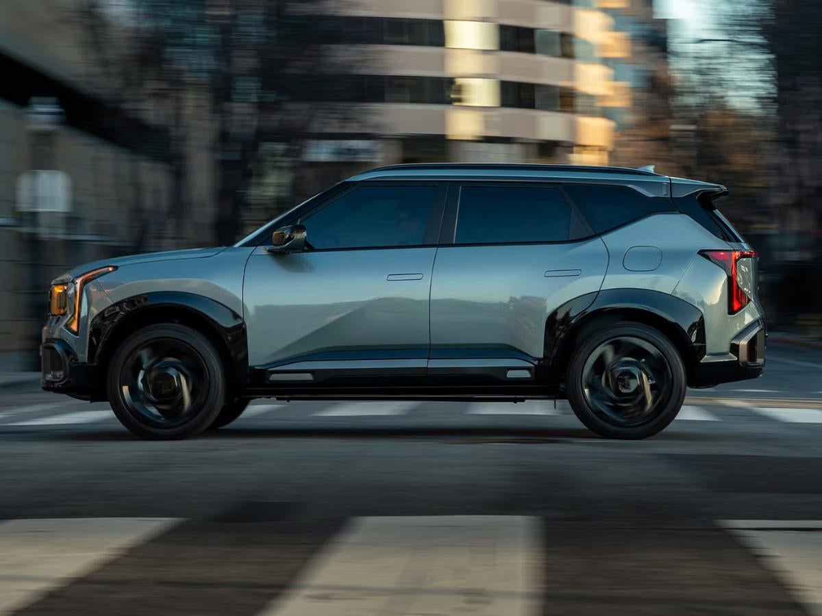 2027 Kia Seltos driving through an urban environment with modern styling and advanced technology features