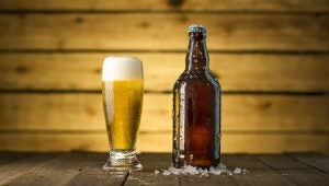 A bottle of beer beside a glass of beer on a table in a brewery. | Craft beer around Sherwood, AR.