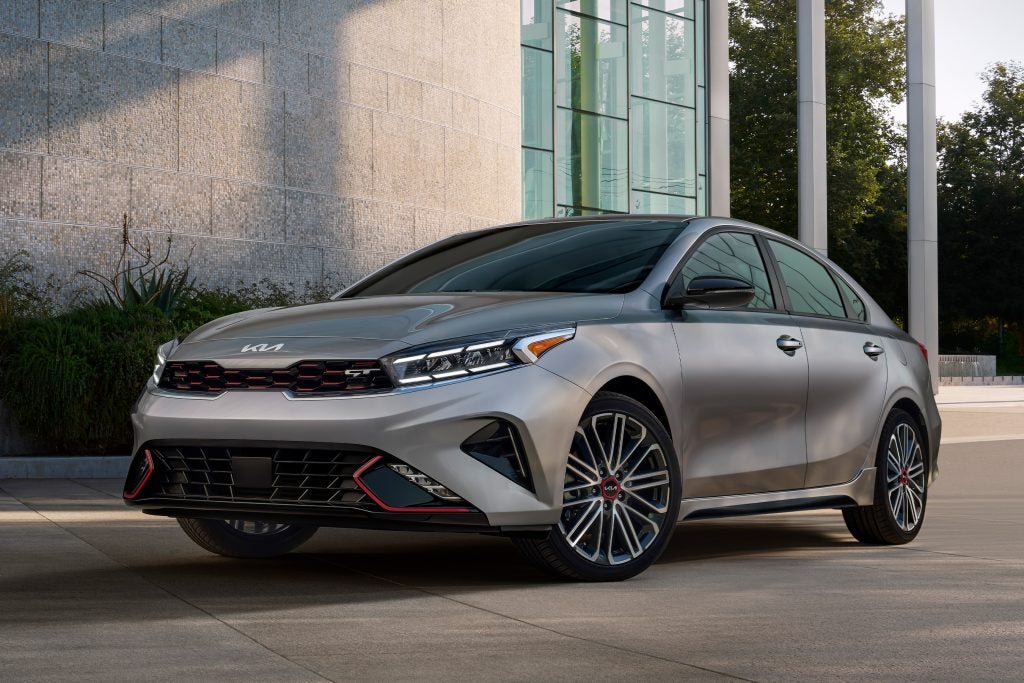 A parked silver 2022 Kia Forte in front of a building. | Kia dealer in Conway, AR.