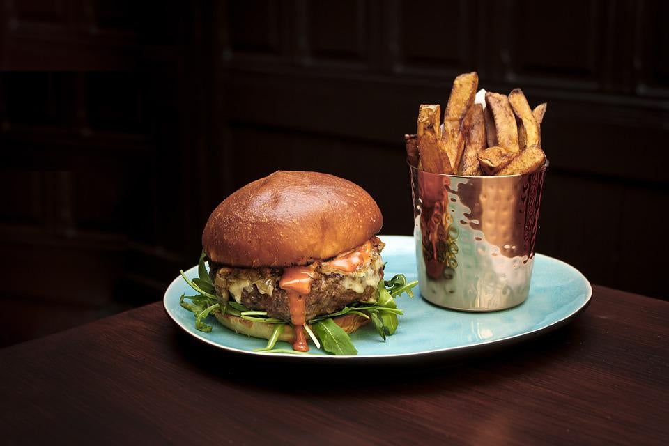 A plate with a cheeseburger and fries on a table. | Family dinner around Bentonville, AR.