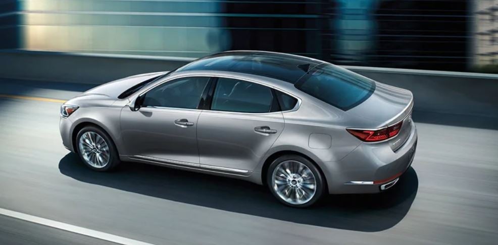 Profile view of a silver 2019 Kia Cadenza being driven on the road. | Kia service center in Bentonville, AR.