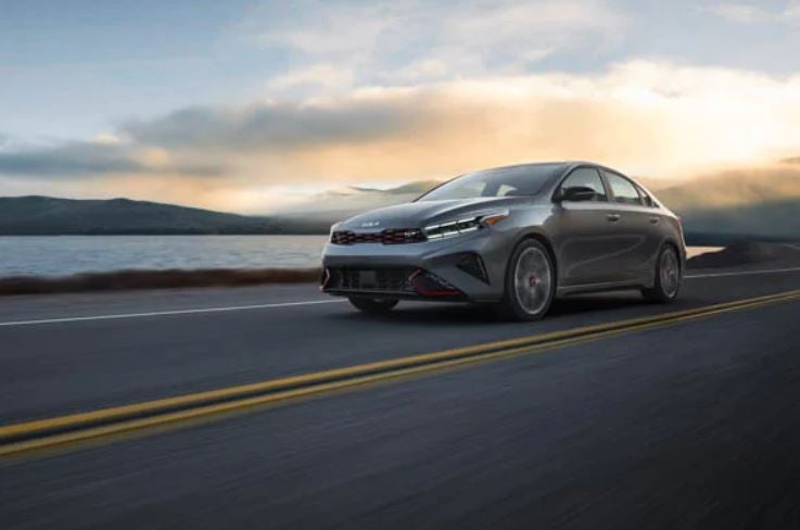 A silver 2022 Kia Forte being driven on the highway. Kia dealer in Bentonville, AR.