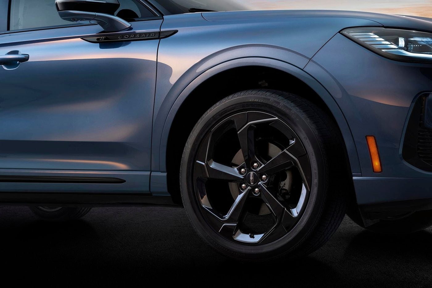 Front corner and black wheel of a blue gray Lincoln Corsair