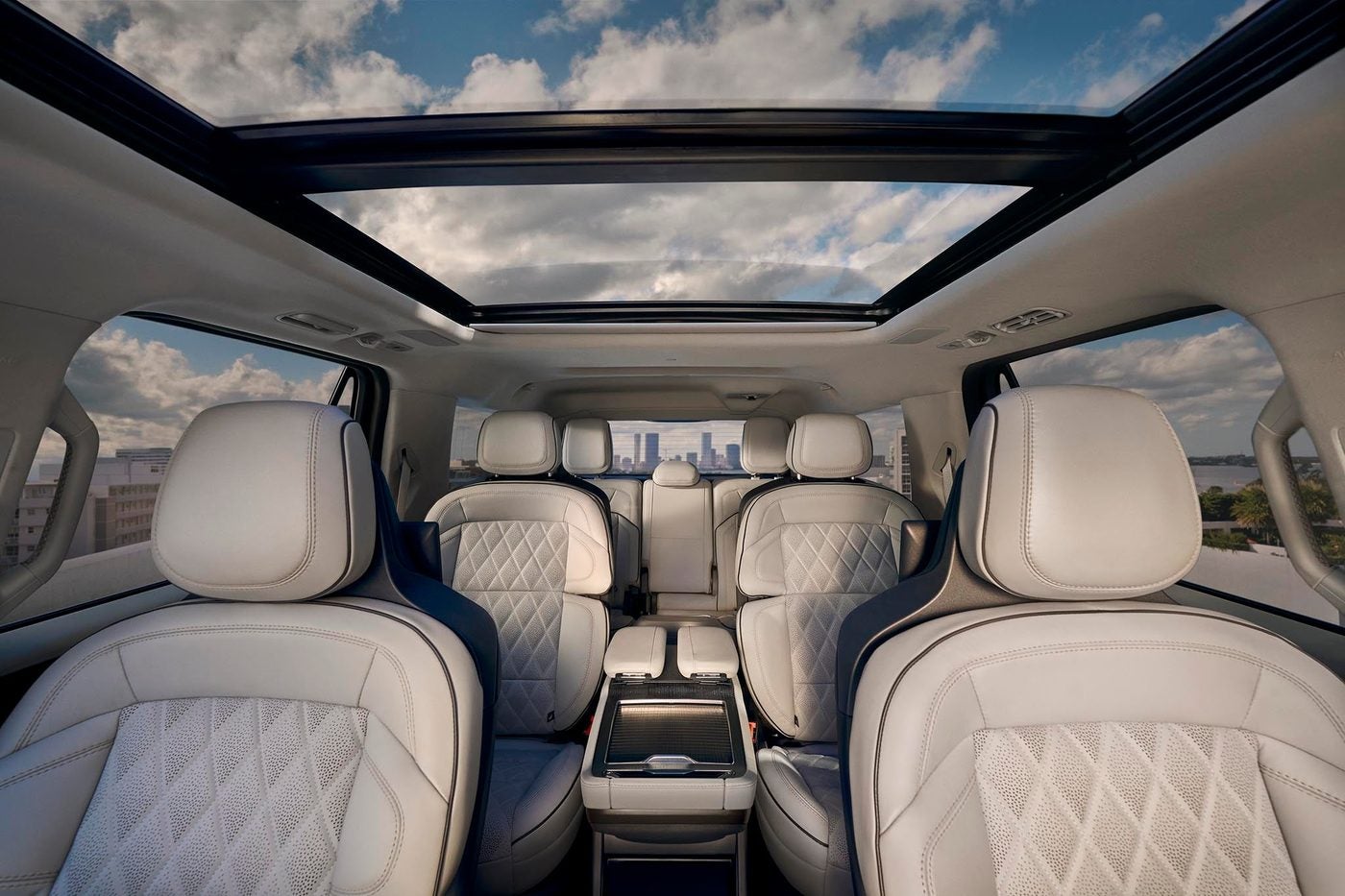 Cream quilted leather second and third row seats inside a Lincoln Navigator under a panoramic roof