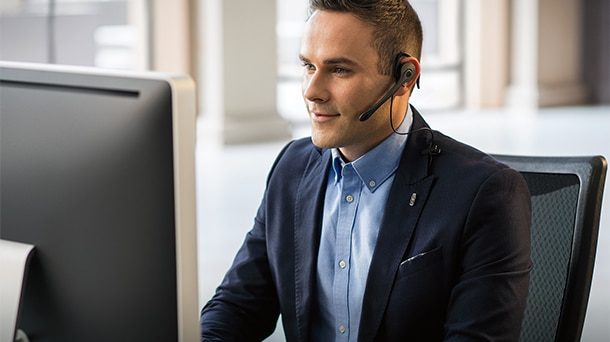 Lincoln service representative in a suit and headset at a computer