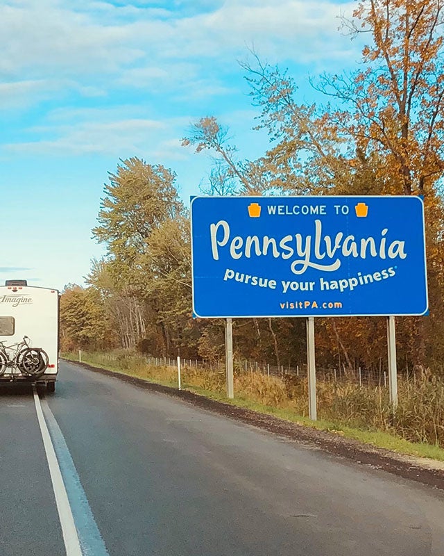 Bennett Hyundai of Lebanon is a Hyundai Dealership in Lebanon near Palmyra, PA | Drivers View of Blue Sign that reads 'Welcome to Pennsylvania' on Right Side of the Road as Car Drives Past it