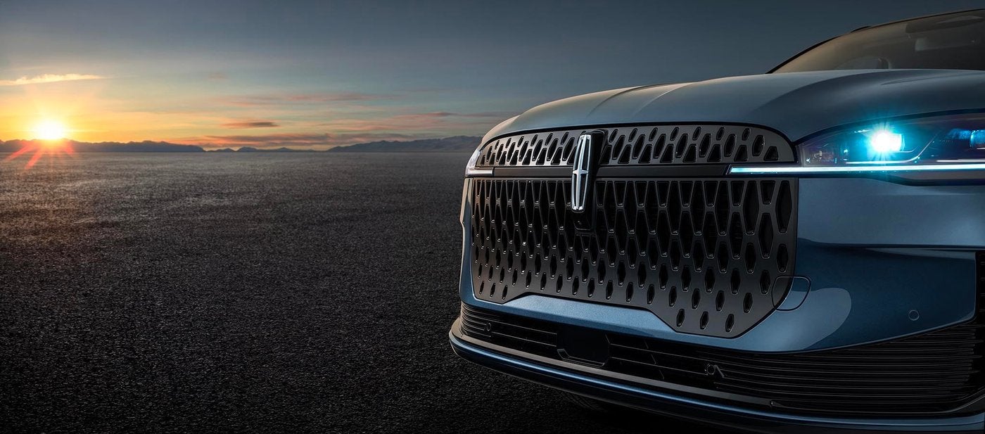 Close view of the Lincoln Corsair grille and headlight at sunset