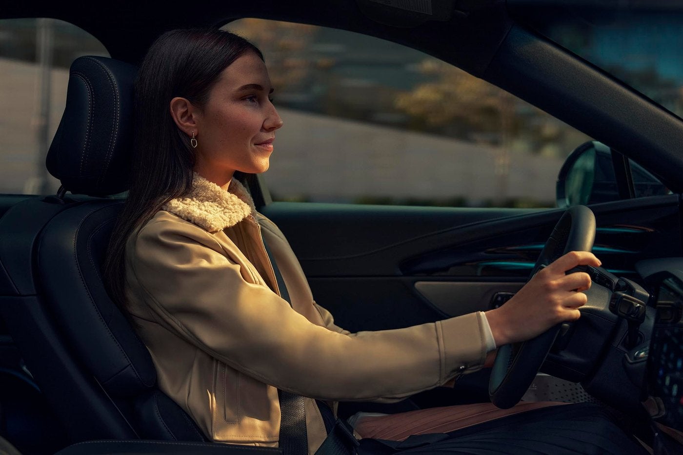 Woman driving a Lincoln Nautilus with both hands on the steering wheel