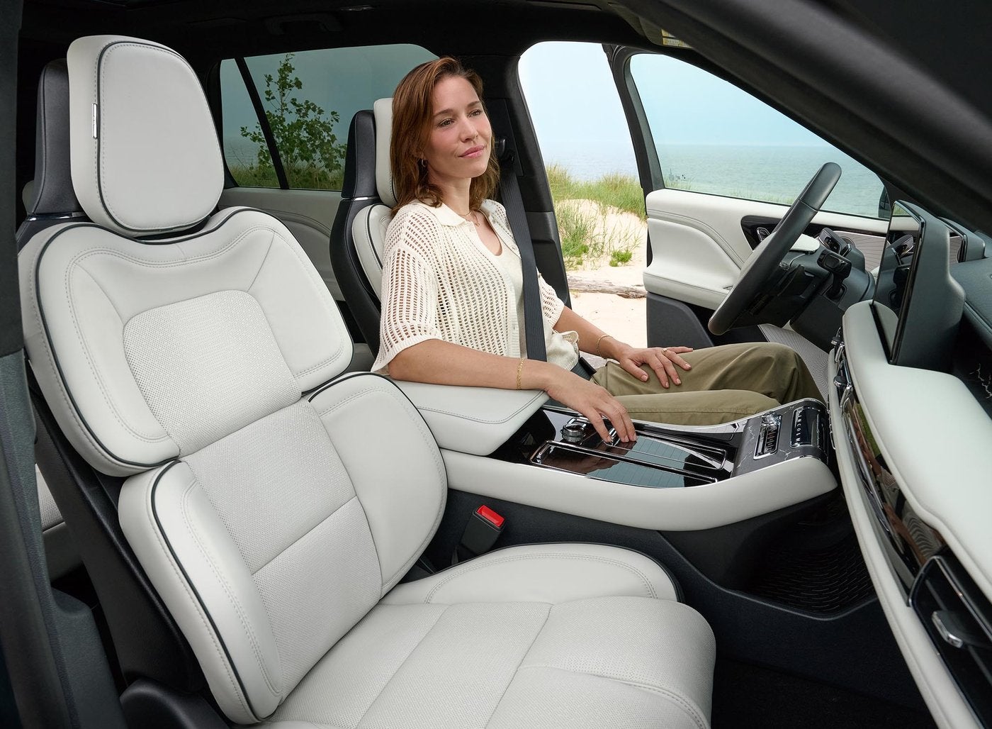 Woman sitting in the white leather driver seat of a Lincoln Aviator