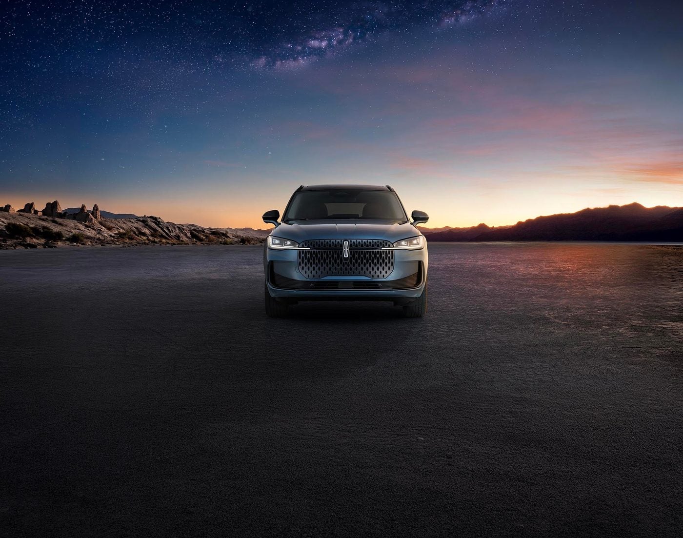 Lincoln Corsair with its headlights and lit grille glowing at night