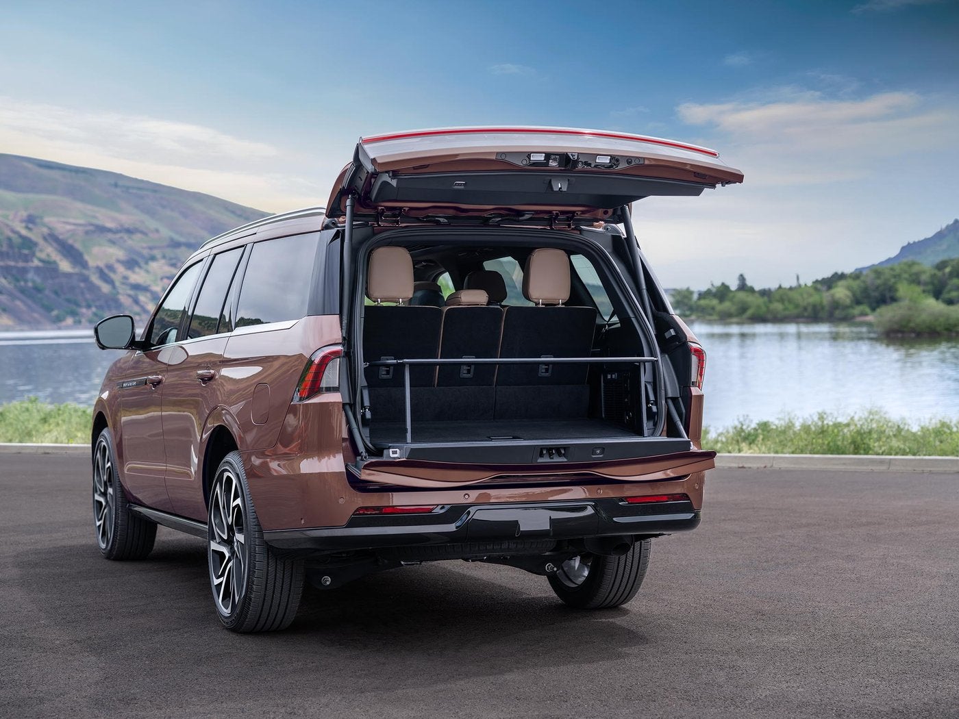 Copper Lincoln Navigator parked by a lake with the split gate open