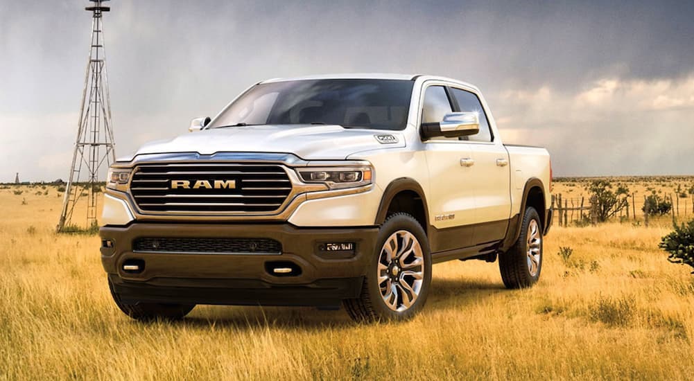 A white 2020 Ram 1500 Laramie Longhorn parked off-road in a field.