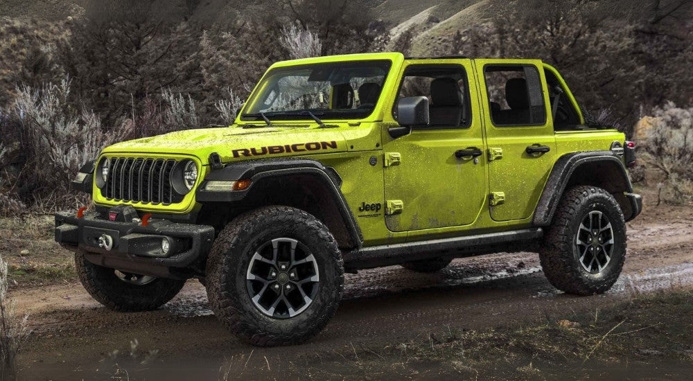A green 2025 Jeep Wrangler Unlimited Rubicon parked on a trail.