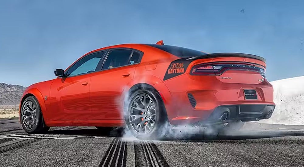 An orange 2023 Dodge Charger King Daytona is shown from the rear at an angle after leaving a Dodge dealer.