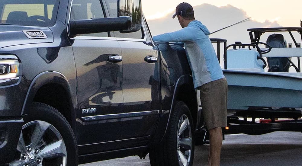 A blue 2022 Ram 1500 is shown in close-up while loading a boat.