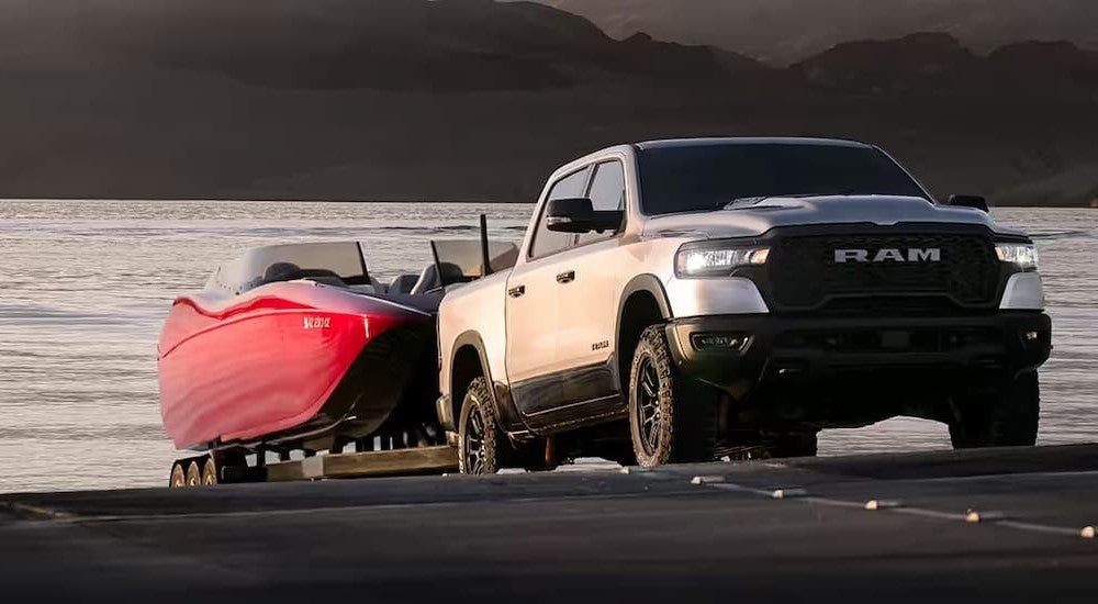 A silver 2025 Ram 1500 towing a boat out of the water.
