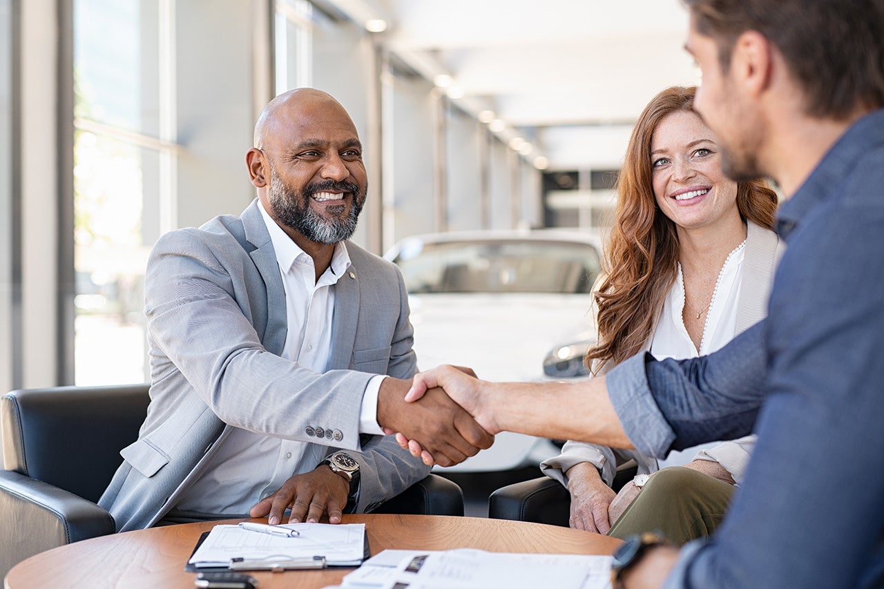 Couple shaking hands after buying Chevy van