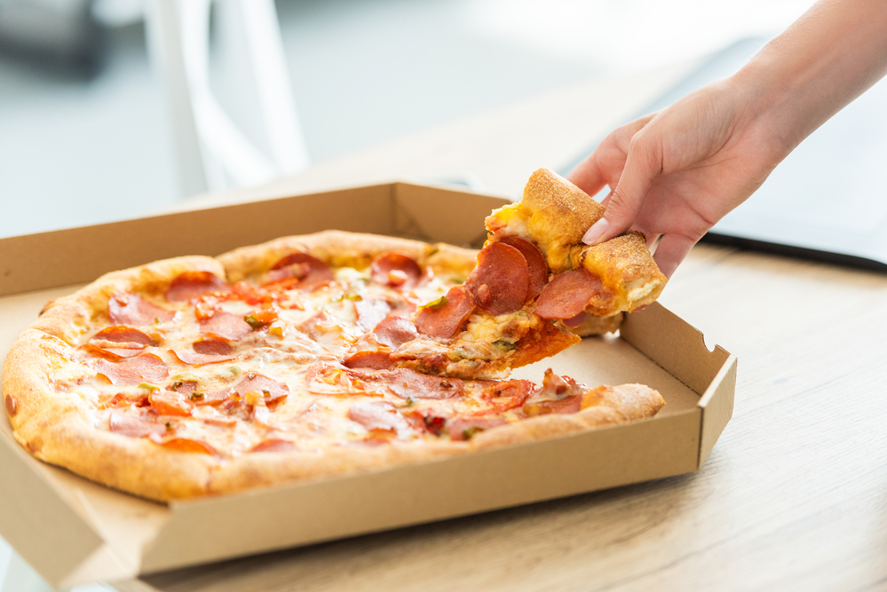 Someone grabbing a slice of pizza