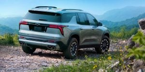 Rear view of a Silver 2024 Chevy Traverse parked overlooking a mountain range | Glenview, IL