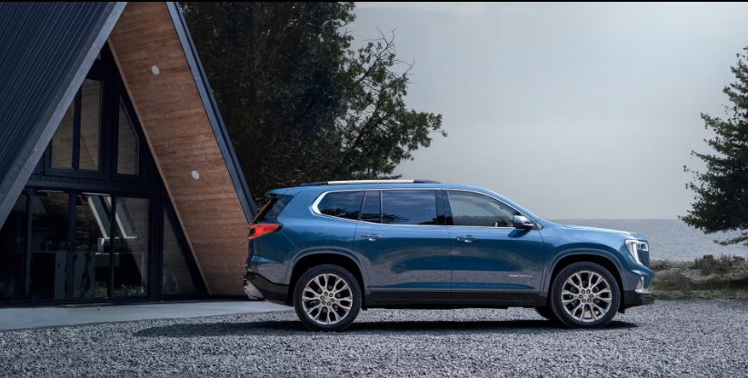 A 2026 GMC Acadia parked in front of a cabin