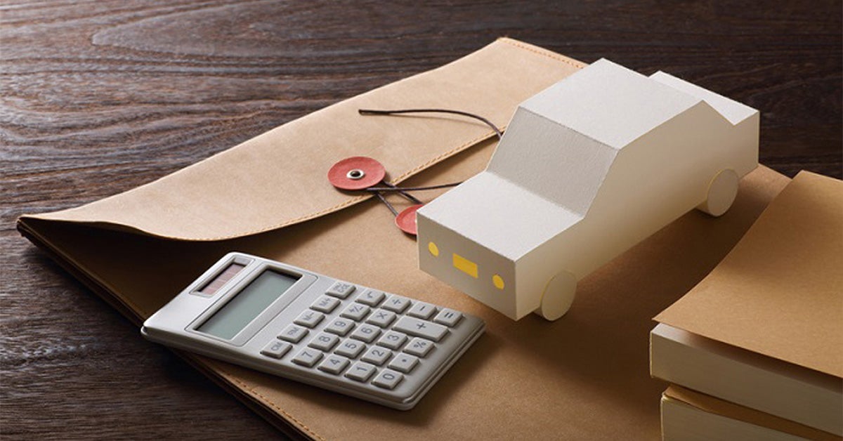 Calculator boxy car and paperwork folder on a desk