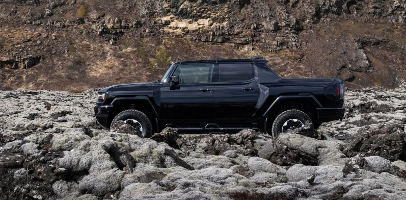 A black 2025 GMC HUMMER EV Pickup offroading.