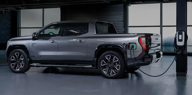 A photo of a 2025 GMC Sierra EV plugged in charging.