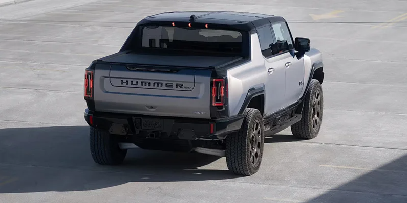 A 2026 GMC Hummer EV Pickup driving away from the camera.