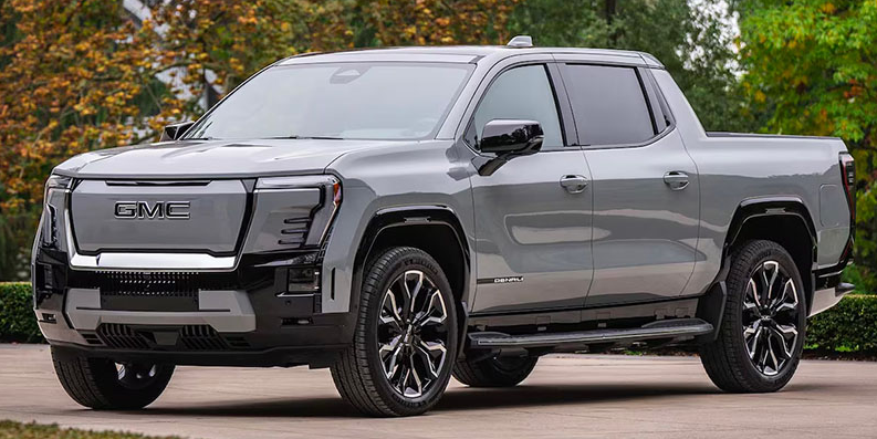 A grey 2026 GMC Sierra EV parked in a driveway.