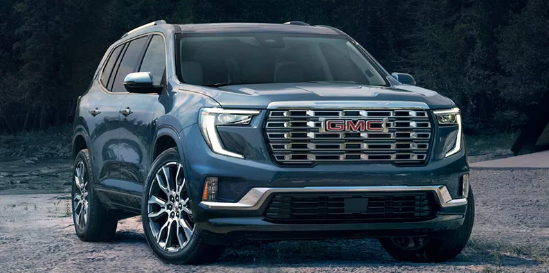 A blue 2025 GMC Acadia parked diagonally to the camera.