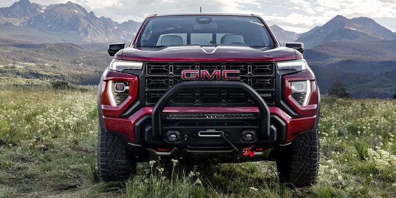 New Red 2026 GMC Canyon standing in mountains.