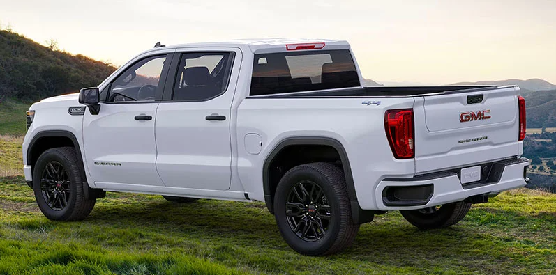 A white 2025 GMC Sierra 1500 parked on a patch of grass.