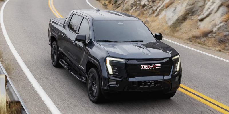 2026 Black GMC Sierra EV cruising on mountain