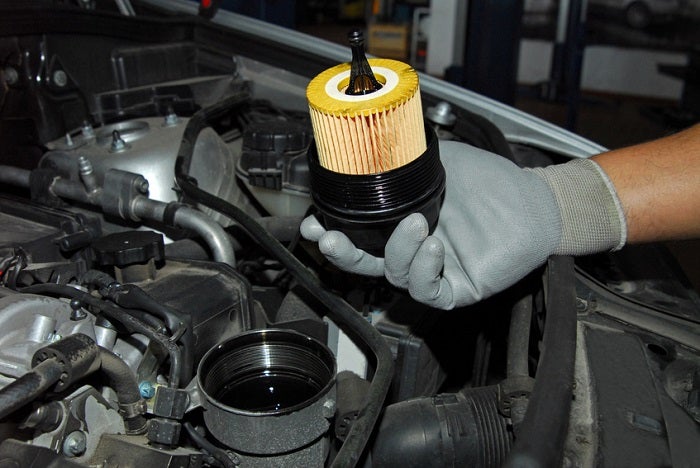 Changing oil filter as part of a Chevy service schedule