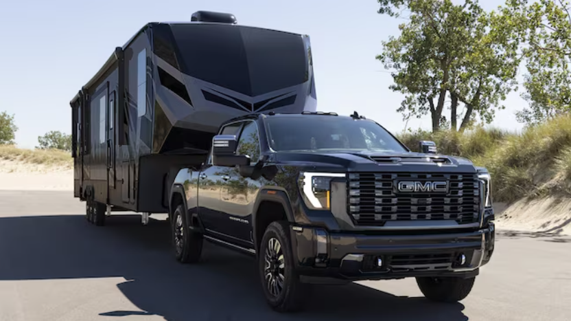 Black 2024 GMC Sierra 2500HD towing an RV.