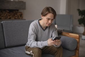 Guy on the phone sitting on the couch.