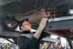 Mechanic checking the transmission under the under.