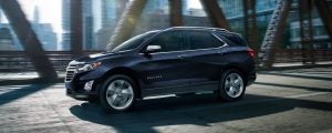 A 2021 Chevrolet Equinox driving through a bridge in the city.