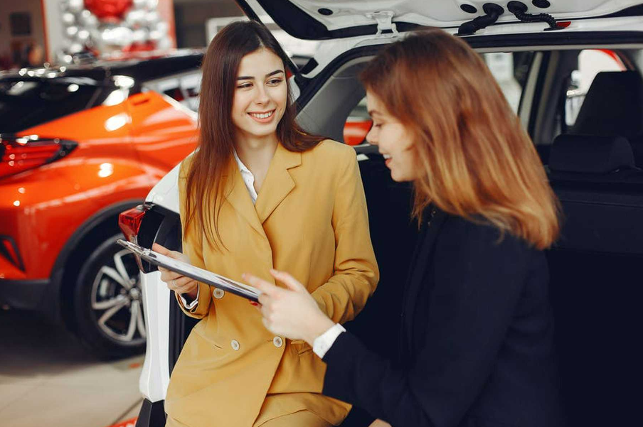 Sales woman and customer looking at paperwork.