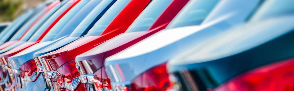 Rear view of colorful cars parked in a row.