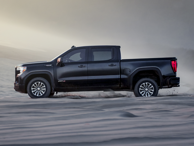 A black GMC Sierra 1500 driving on sand