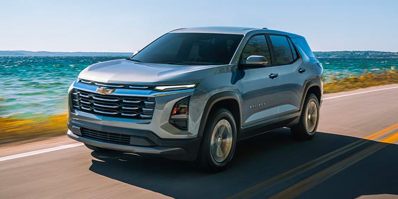 Chevrolet Traverse driving along a coastal road with the ocean in the background