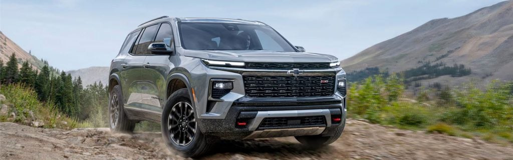 Gray SUV driving on a rocky mountain trail.