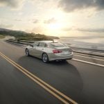 Rear view of the 2024 Chevrolet Malibu Premier 1LZ in Mineral Gray Metallic driving down a road