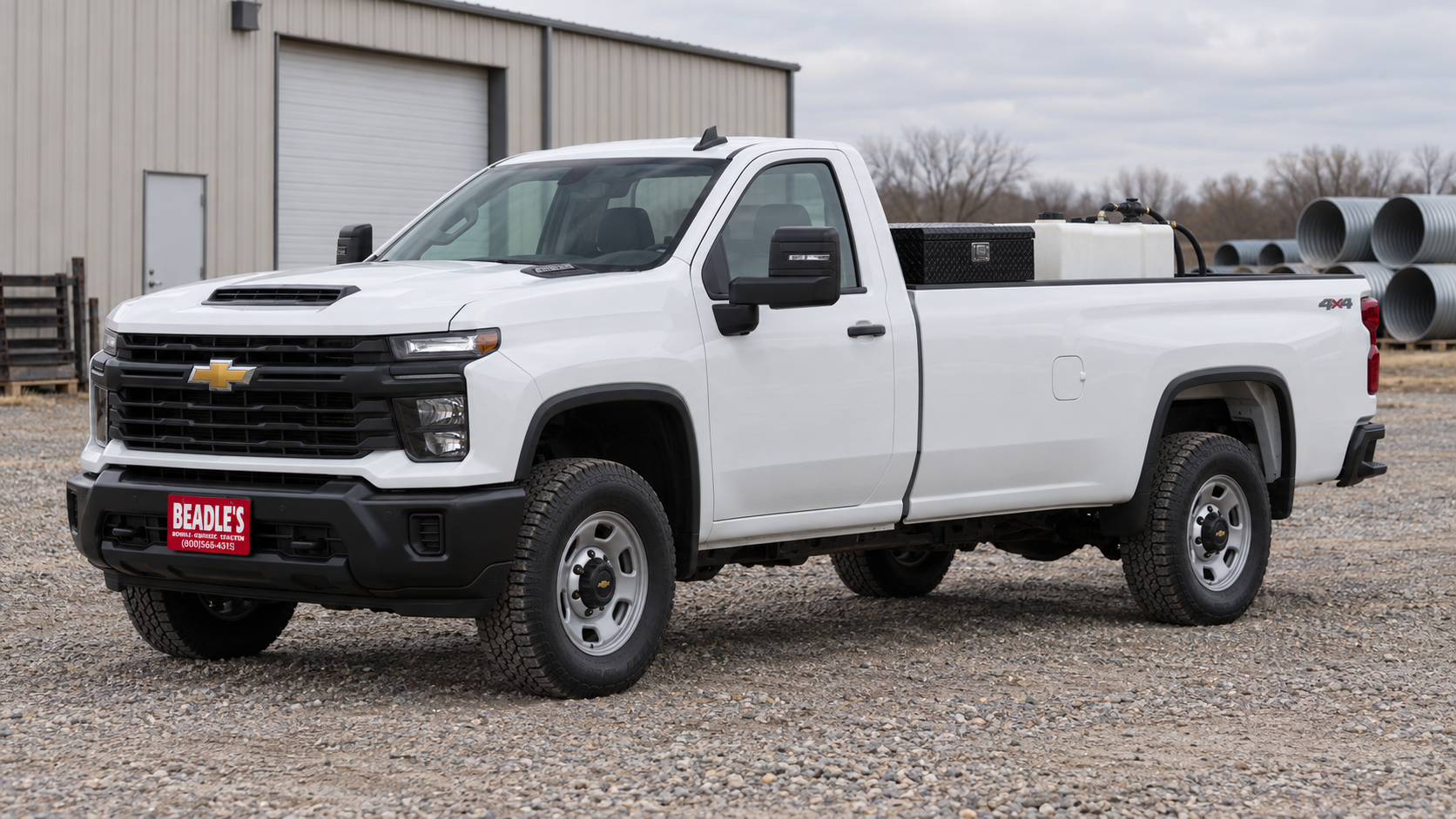 Chevrolet Silverado 2500 HD Work Truck Regular Cab long bed with a toolbox and transfer tank in a county shop yard