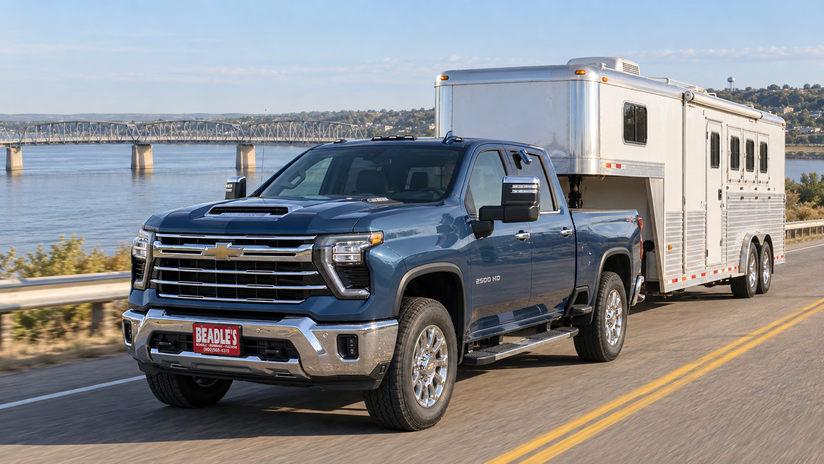 Chevrolet Silverado 2500 HD LTZ in Lakeshore Blue Metallic towing a living-quarters horse trailer near the Missouri River bridge at Mobridge
