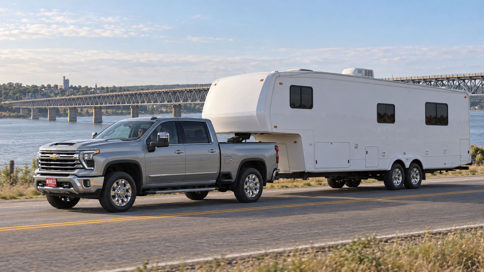 Chevrolet Silverado 3500 HD LTZ in Sterling Gray Metallic towing a fifth-wheel camper past the Missouri River bridge at Mobridge