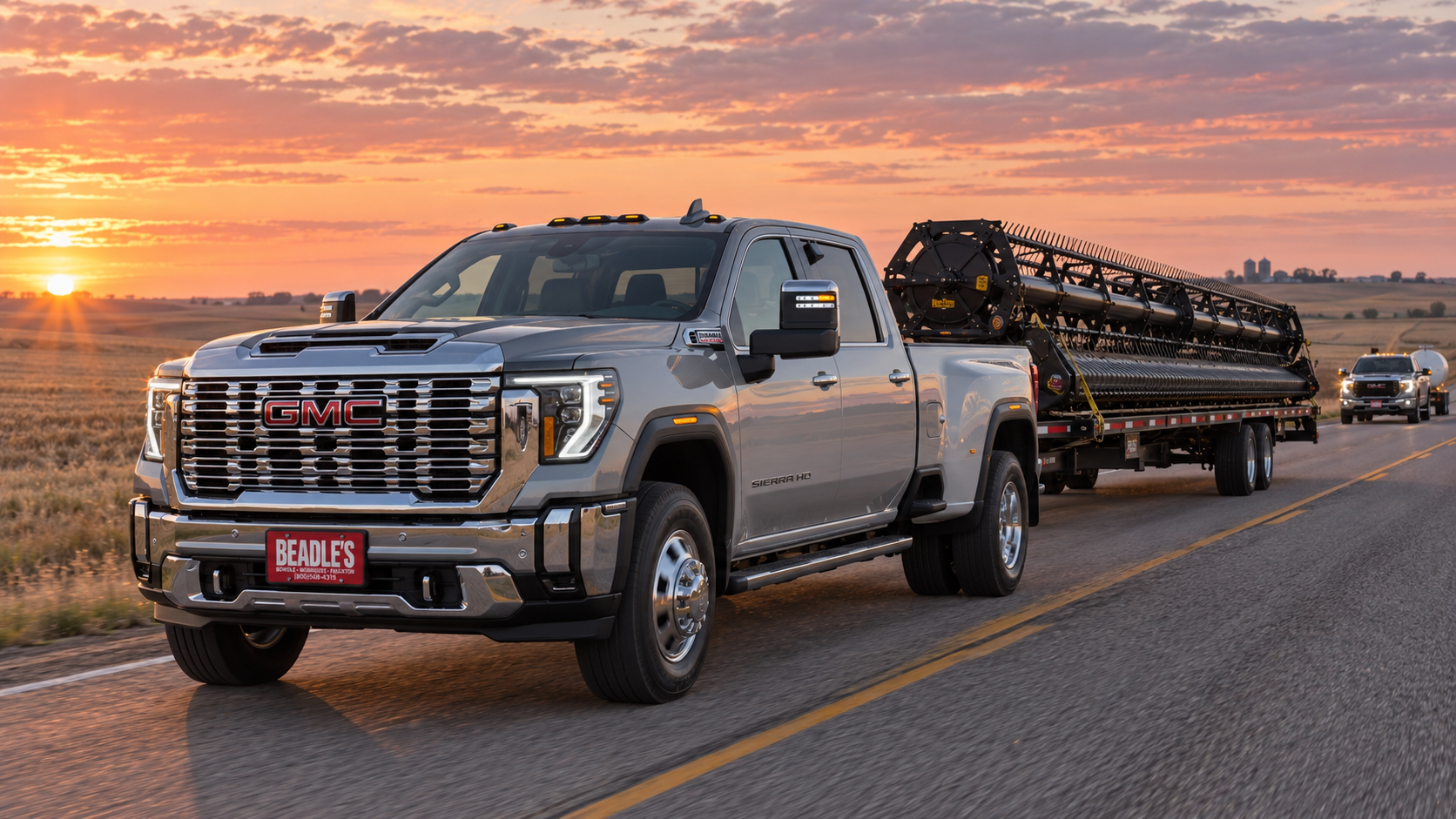 2026 GMC Sierra 3500 HD SLT dually pulling a combine header trailer at dawn on a two-lane near Mobridge, South Dakota
